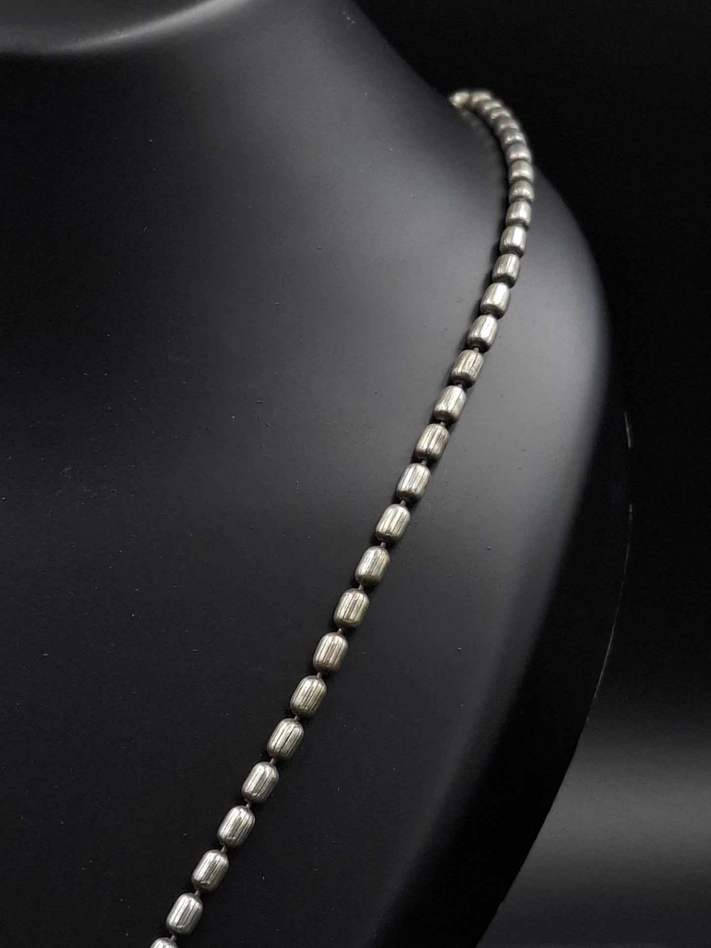 Silver chain on a black leather surface