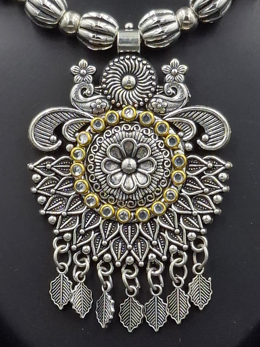 Decorative silver and gold pendant on a black background