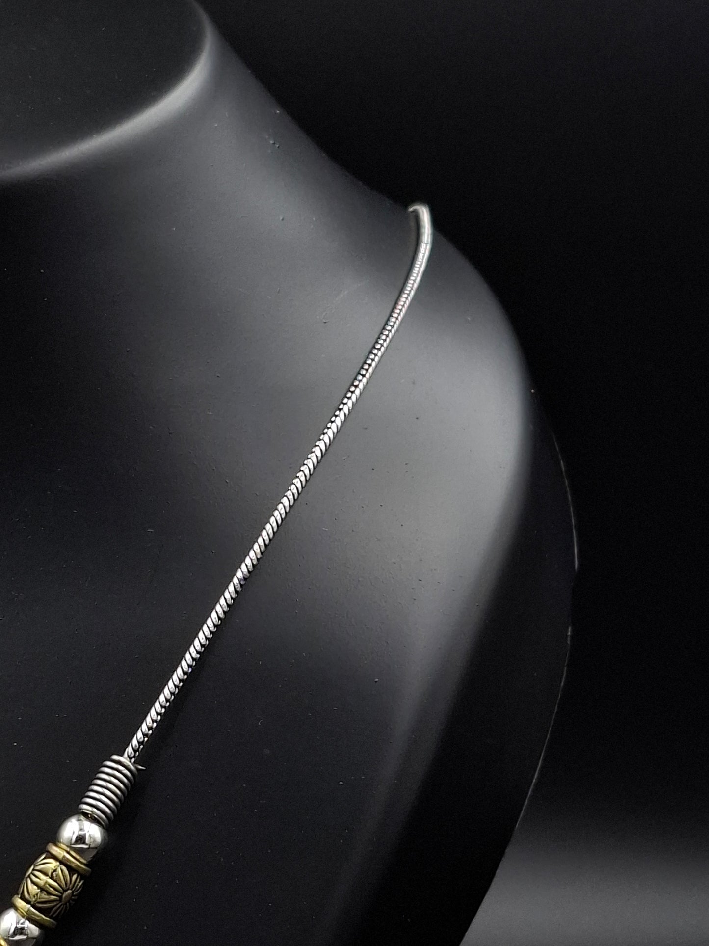 Silver chain necklace on a dark surface