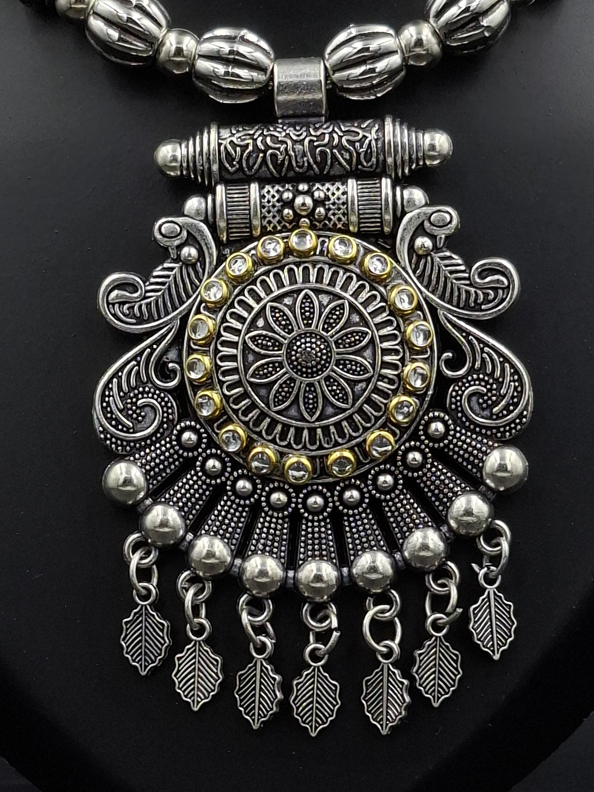 Decorative silver bracelet with intricate designs on a black background