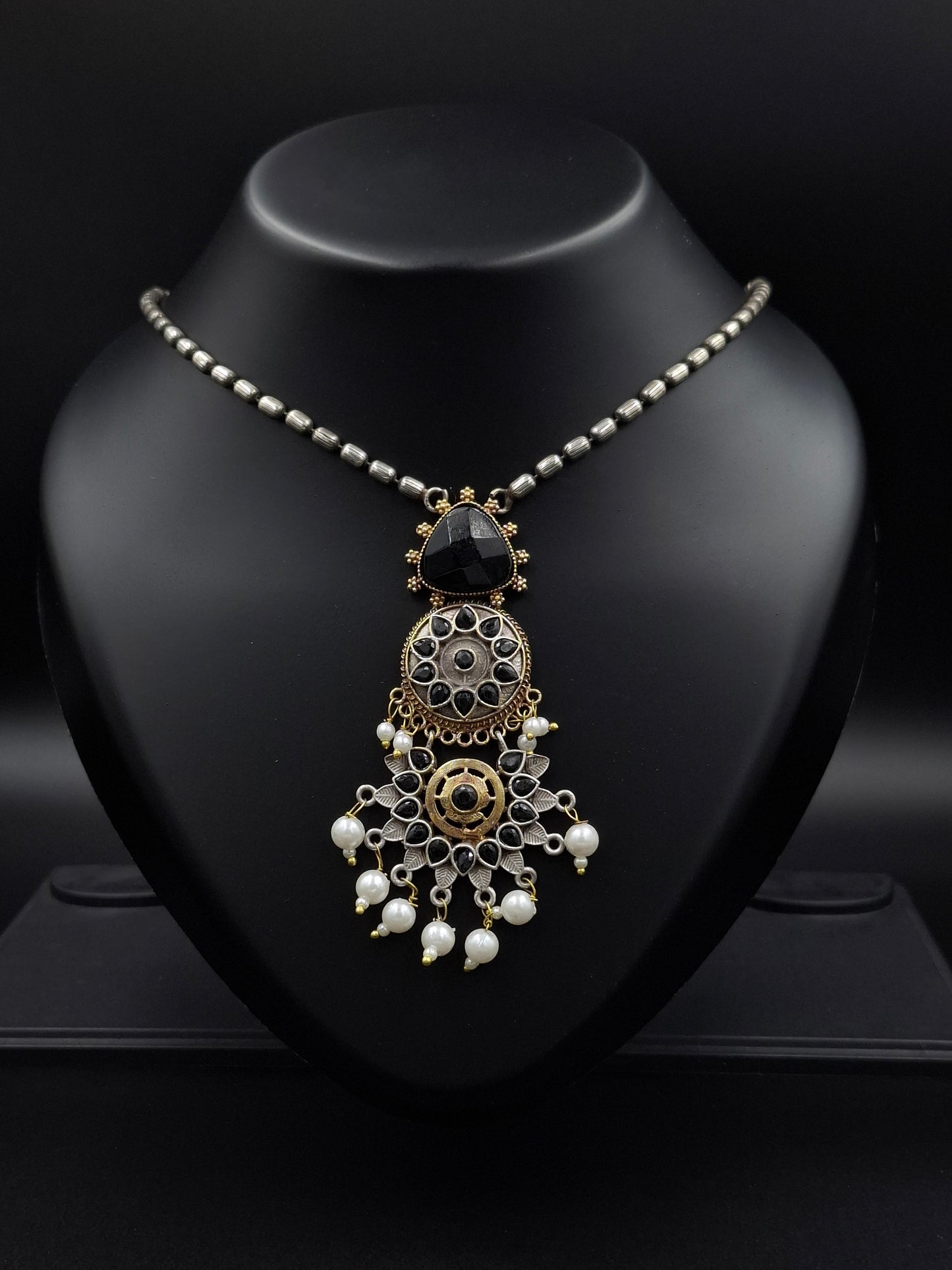 Decorative headband with intricate design on a black stand