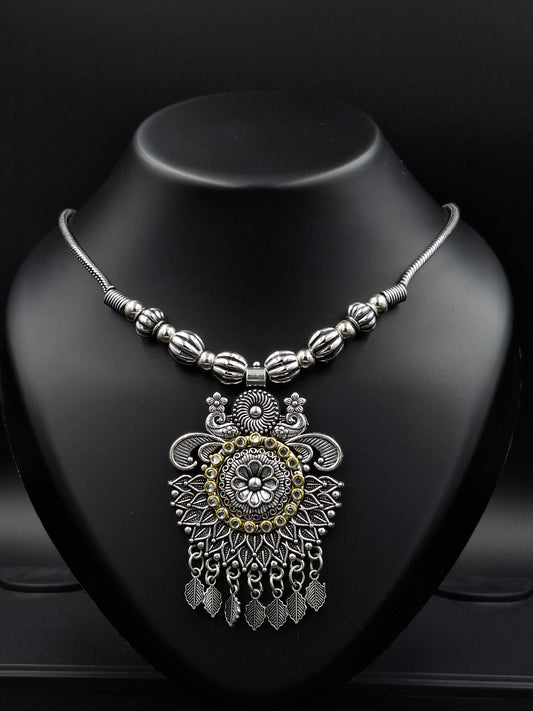 Decorative silver and gold pendant on a dark surface