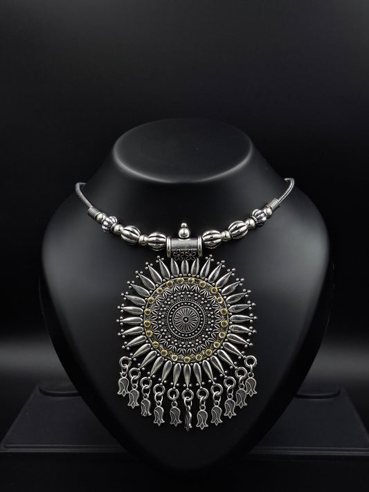 Ornate silver earring on a black stand against a dark background