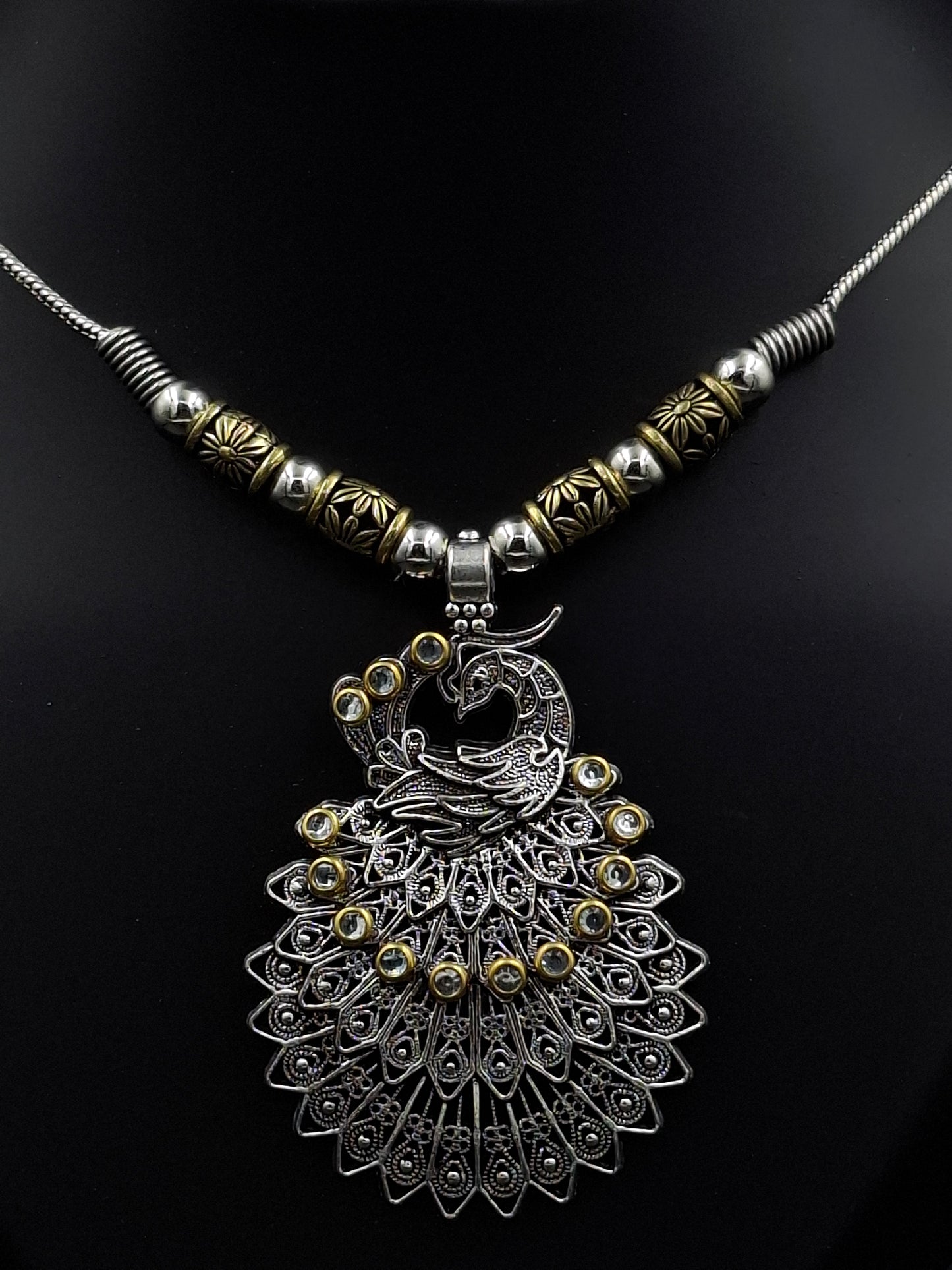 Decorative peacock feather hair accessory on a black background