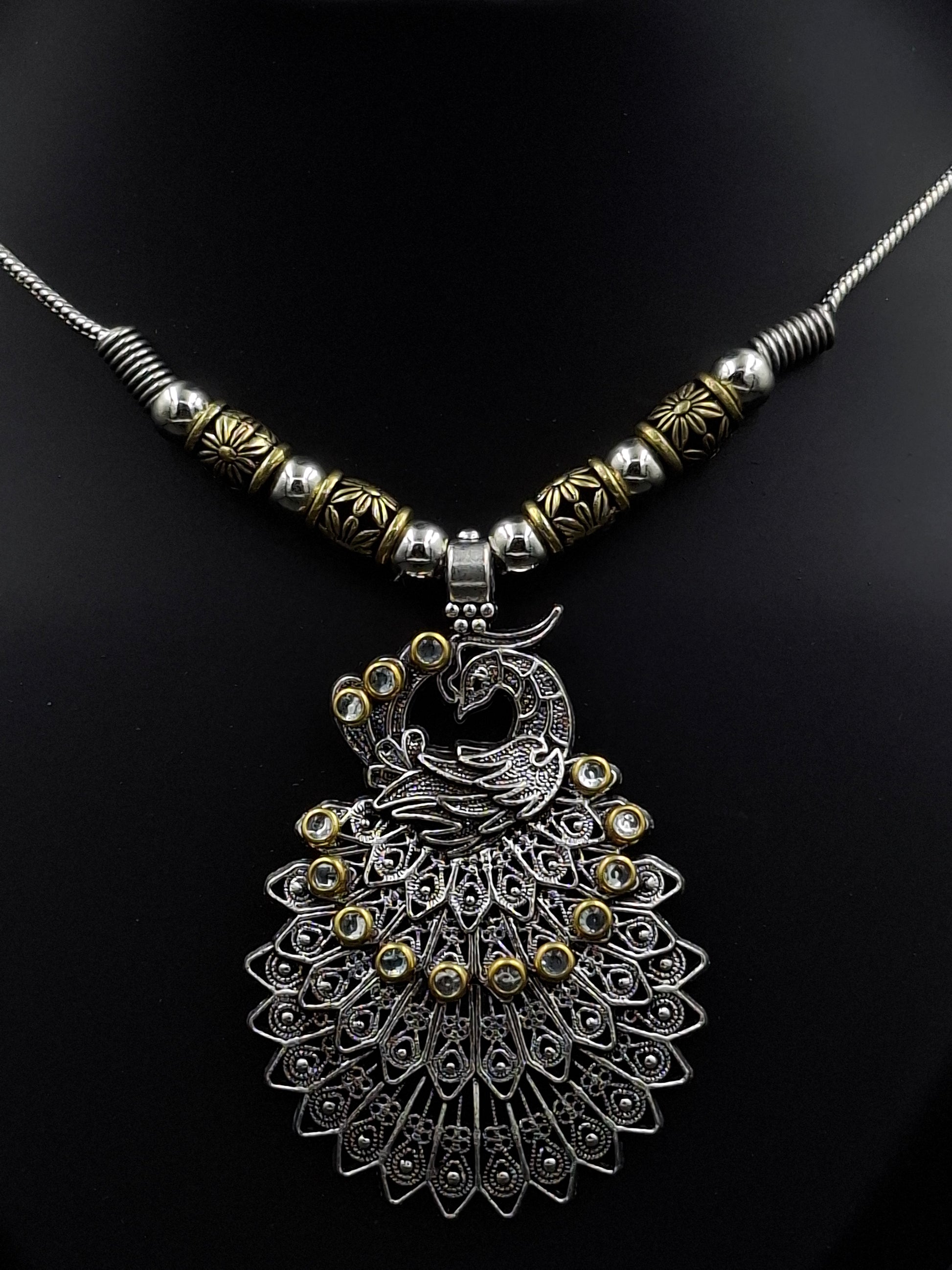 Decorative peacock feather hair accessory on a black background