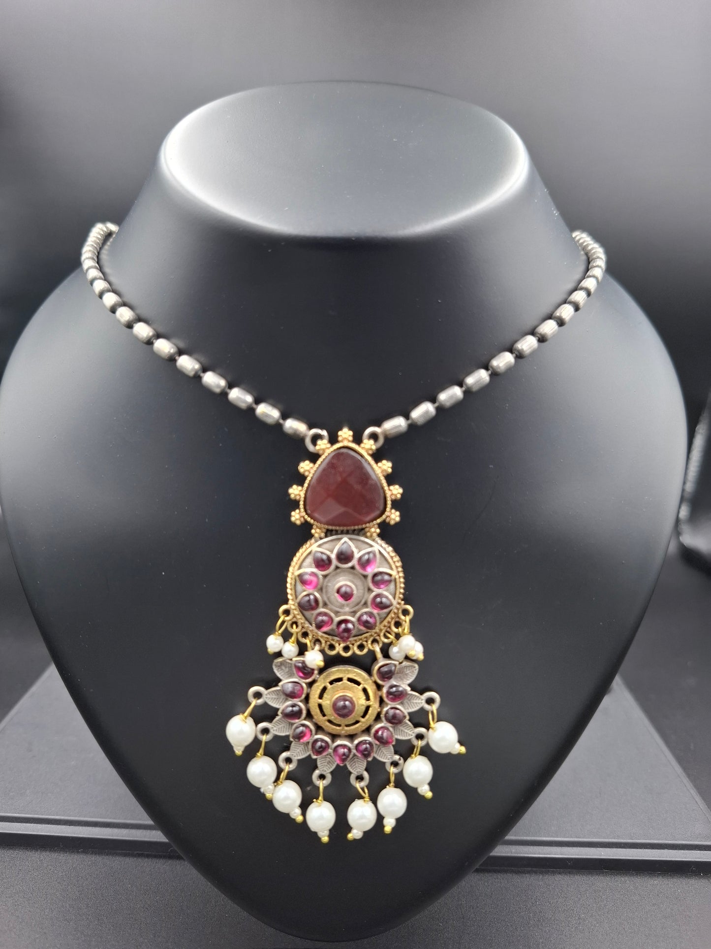 Decorative headband with gold and silver design on a black mannequin head.