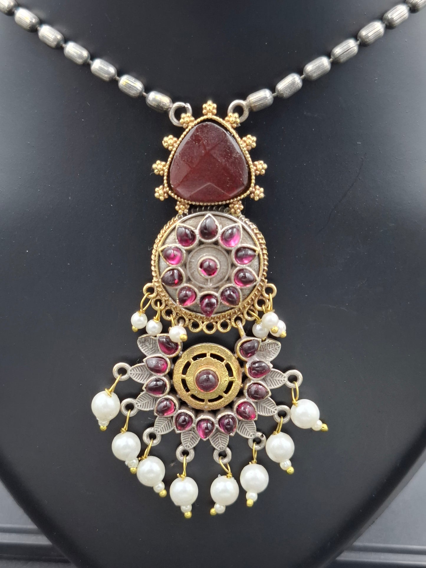 Decorative necklace with intricate design on a dark surface
