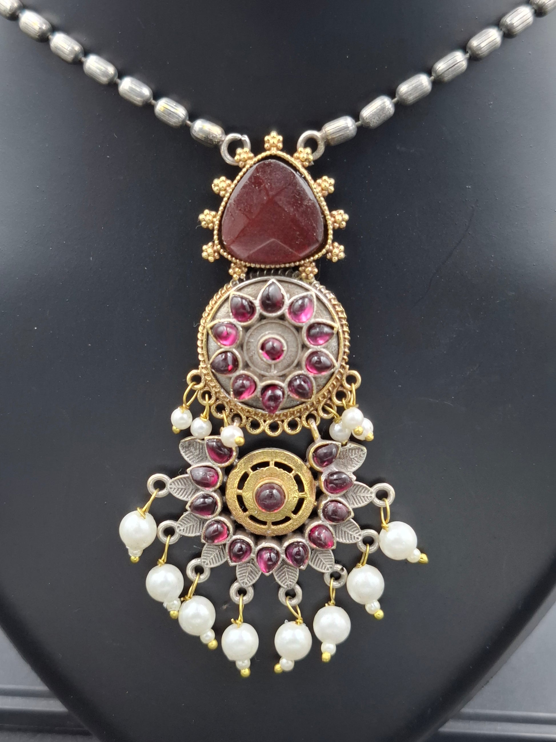 Decorative necklace with intricate design on a dark surface