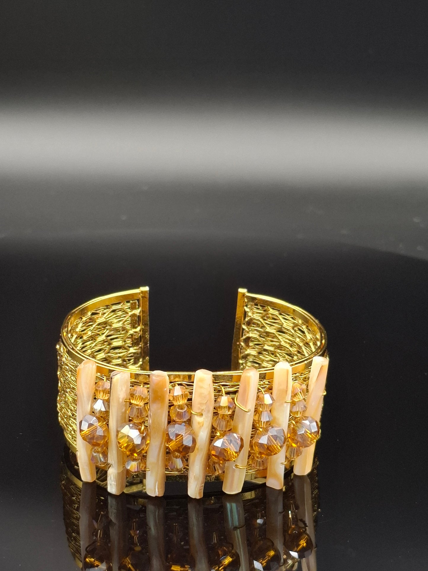 Gold letter 'E' with embedded stones on a black background