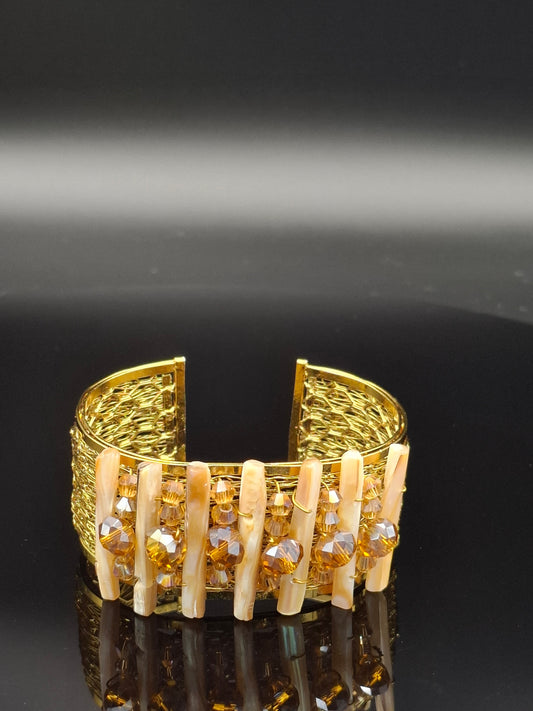 Gold letter 'E' with embedded stones on a black background