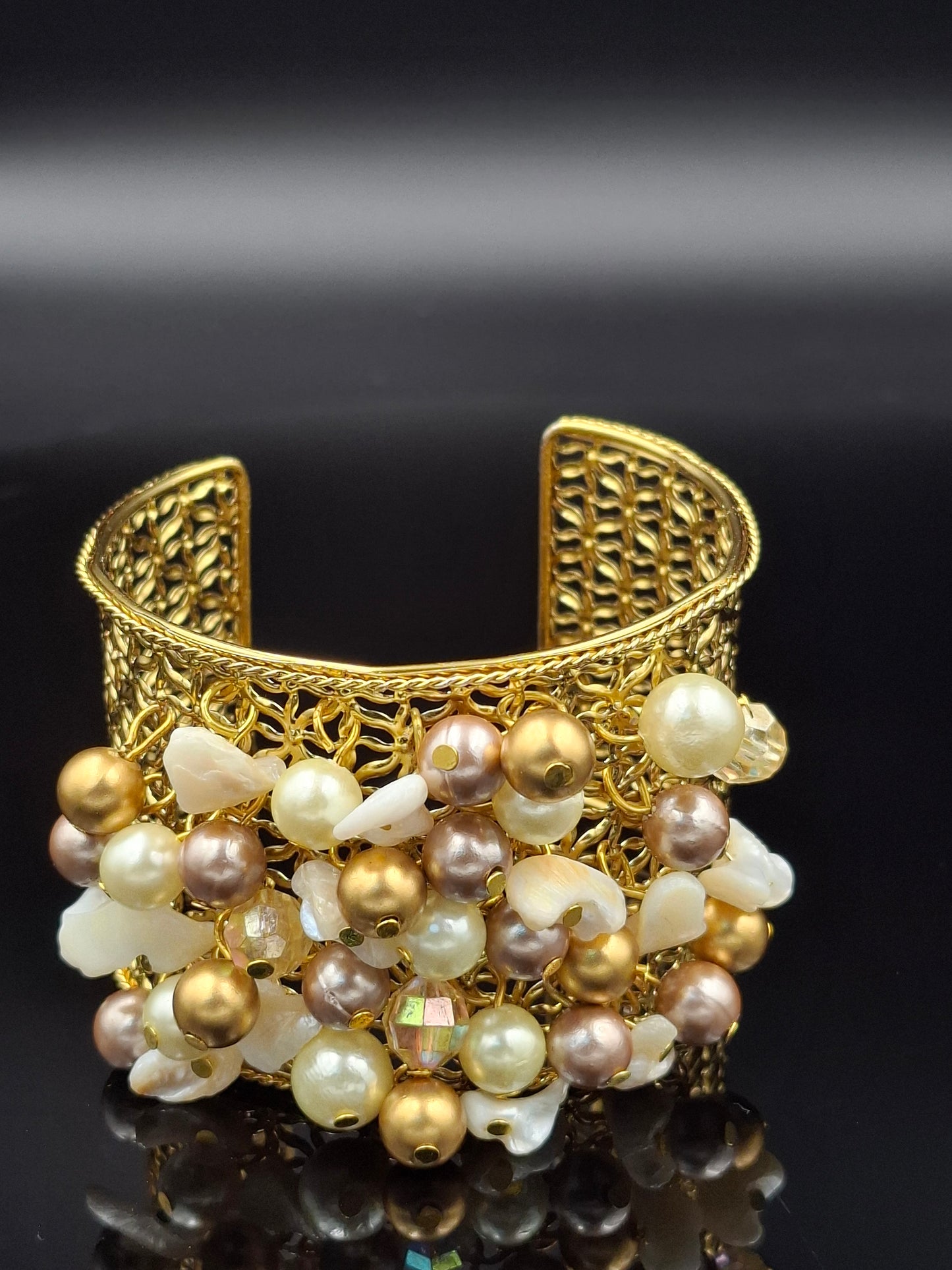 Gold brooch with pearls on a black background