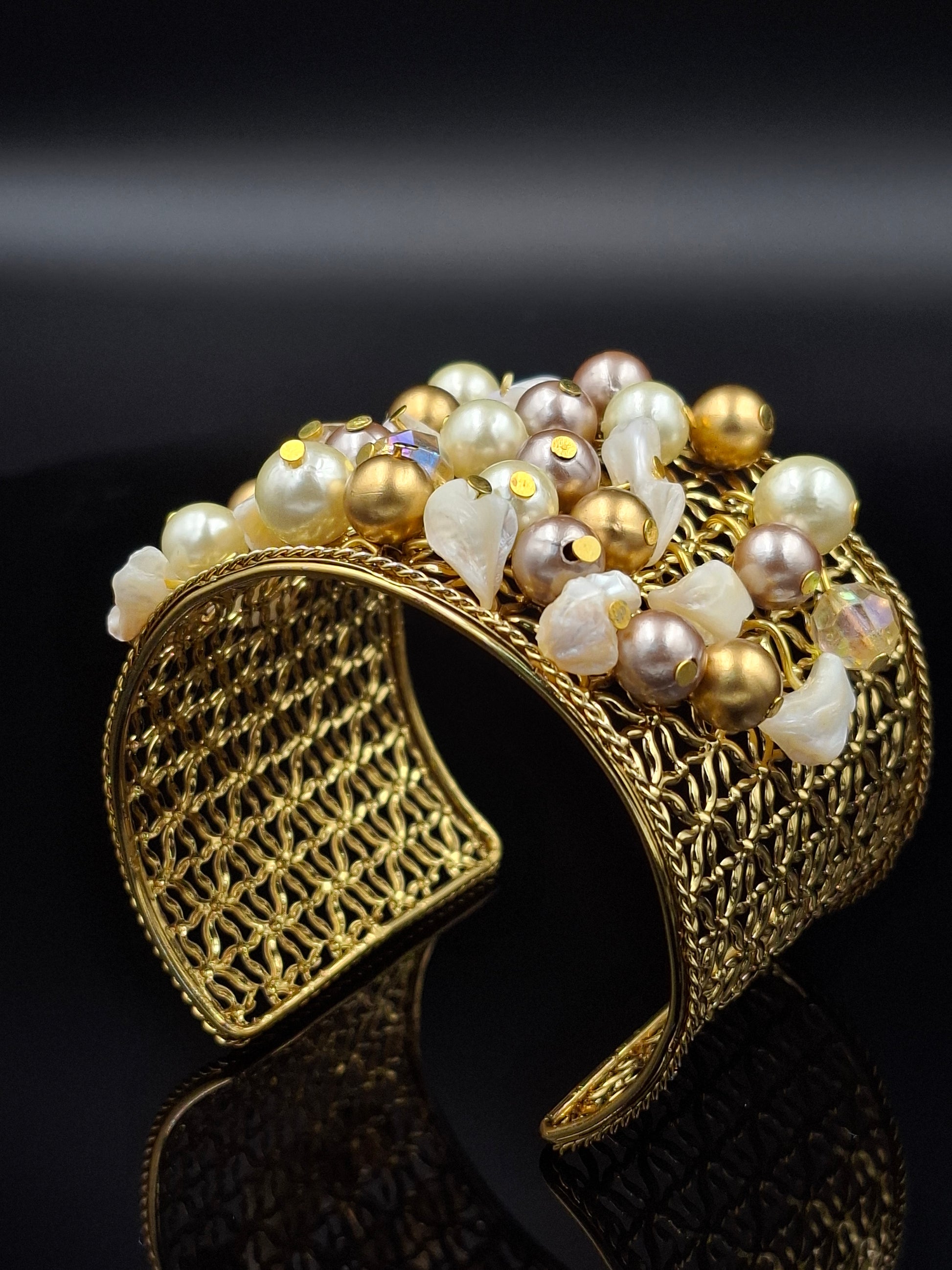 Gold bracelet with pearls on a black background