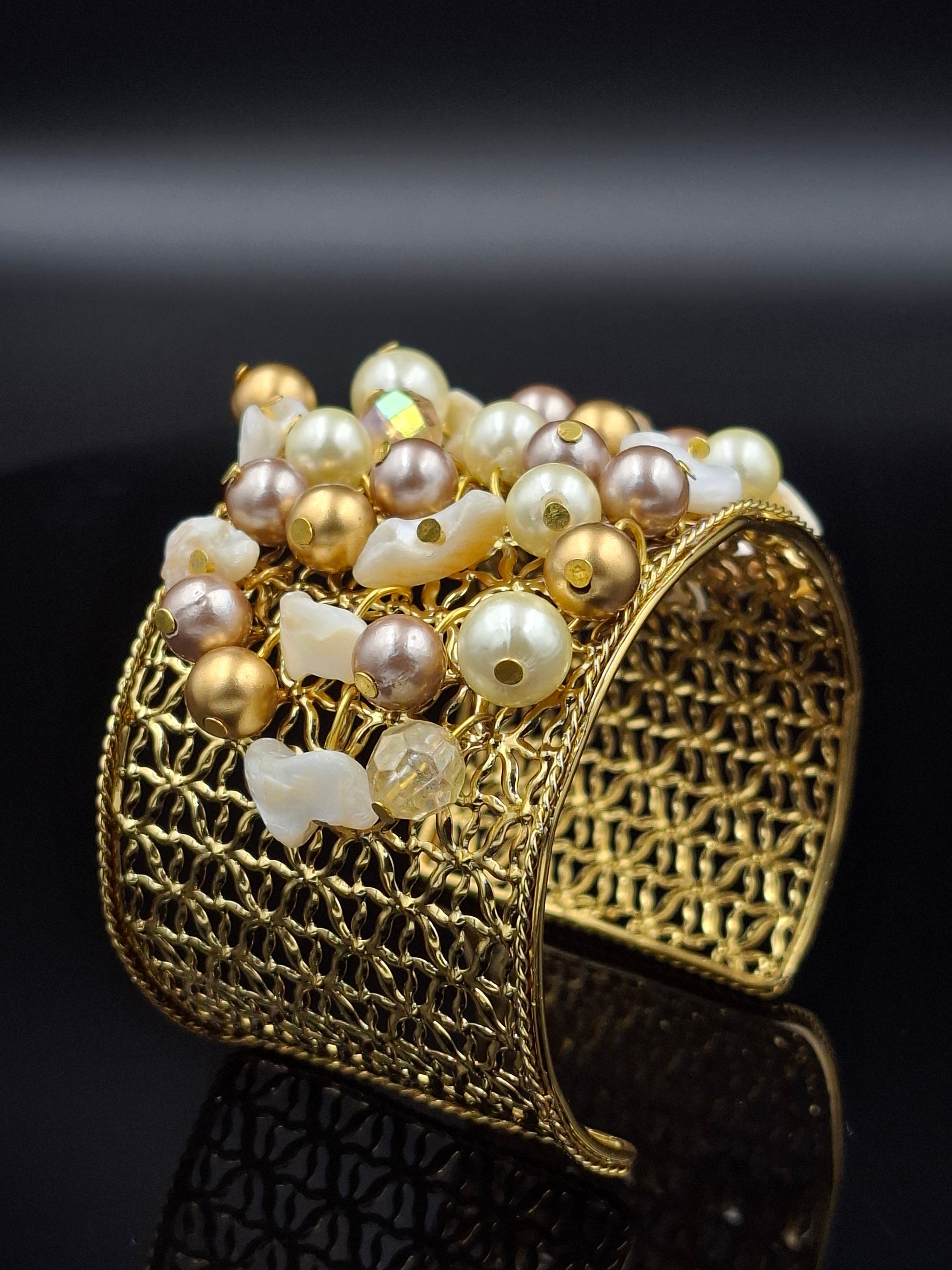 Gold bracelet with pearls on a black background